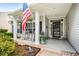 Cozy front porch featuring rocking chairs, an American flag, and a welcoming entrance to the home at 9616 Pebble Creek Blvd, Summerville, SC 29485