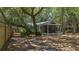 A spacious backyard with a screened-in porch area nestled among mature trees for shade and privacy at 10 Chapman Ave, Isle of Palms, SC 29451