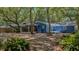 Backyard featuring blue siding, deck with steps, and lush landscaping and surrounding trees at 10 Chapman Ave, Isle of Palms, SC 29451