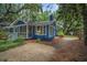 Charming home exterior features screened porch, blue siding, lush landscaping, and gravel pathway at 10 Chapman Ave, Isle of Palms, SC 29451