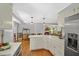 Open concept kitchen with white cabinets and hardwood floors, leading to a bright living area at 10 Chapman Ave, Isle of Palms, SC 29451