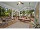 Inviting screened porch featuring a cozy swing, outdoor furniture and lush greenery at 10 Chapman Ave, Isle of Palms, SC 29451