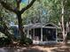 Side view of a blue cottage with a spacious screened porch, perfect for enjoying the outdoors at 10 Chapman Ave, Isle of Palms, SC 29451