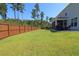 A large fenced yard with lush green grass leads to a home with an enclosed porch and seating at 103 Granton Edge Ln, Summerville, SC 29486