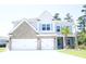 Charming two-story home featuring a brick and siding facade, a three-car garage, and lush landscaping at 103 Granton Edge Ln, Summerville, SC 29486