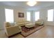 Bright living room featuring hardwood floors, neutral walls, a cream couch, and a large window at 103 Granton Edge Ln, Summerville, SC 29486