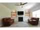 Comfortable living room featuring a fireplace, built-in bookshelves, hardwood floors, and two brown armchairs at 103 Granton Edge Ln, Summerville, SC 29486