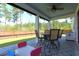 Screened porch with ceiling fan, dining set, and enclosed privacy shades, perfect for outdoor dining and entertaining at 103 Granton Edge Ln, Summerville, SC 29486