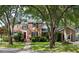 Charming brick home with a well-manicured lawn, lush trees, and inviting red front door at 1067 Loyalist Ln, Mount Pleasant, SC 29464