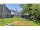 A fenced-in backyard with a garden area and a stone fire pit surrounded by grass and a mature tree at 112 Worthington Dr, Moncks Corner, SC 29461