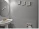 Elegant powder room with pedestal sink, oval mirror, and decorative wall art at 112 Worthington Dr, Moncks Corner, SC 29461