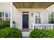 Inviting home front entrance with a black door, trimmed windows, and a cozy porch seating area at 123 Gaslight Blvd, Summerville, SC 29483