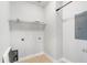 Functional laundry room with shelving, utility sink, and neutral tones, ready for efficient household tasks at 123 Gaslight Blvd, Summerville, SC 29483