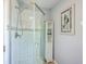 Modern bathroom features glass shower door, white tiled shower, storage cabinet, and decorative art at 131 Harvey Ave, Goose Creek, SC 29445