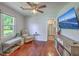 Well-lit bedroom with recliner, mounted television, hardwood floors, and plenty of natural light at 131 Harvey Ave, Goose Creek, SC 29445