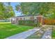 Brick home with a lush green lawn, an American flag on the porch, and a paved driveway at 131 Harvey Ave, Goose Creek, SC 29445