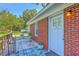 Inviting front door with brick siding, a wooden deck, and stylish outdoor decor creates a warm welcome at 131 Harvey Ave, Goose Creek, SC 29445