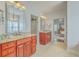 Bathroom featuring double sinks, granite countertops, wood cabinets, and a view into bedroom at 139 Back Tee Cir, Summerville, SC 29485