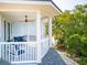 View of the balcony with outdoor seating and a ceiling fan overlooking the green trees in this bright, airy home at 1621 Folly Creek Way # D-8, Charleston, SC 29412