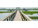 View down a wooden pier that leads to a boat dock and lift on a marsh waterway at 1621 Folly Creek Way # D-8, Charleston, SC 29412