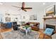 Inviting open concept living room with hardwood floors, kitchen access, leather sofas, and a cozy fireplace at 1621 Folly Creek Way # D-8, Charleston, SC 29412