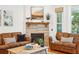 Comfortable living room featuring a cozy fireplace, leather sofas, hardwood floors, and classic décor at 1621 Folly Creek Way # D-8, Charleston, SC 29412