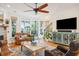 Bright living room with hardwood flooring, sliding doors to porch, leather furniture, fireplace and open staircase at 1621 Folly Creek Way # D-8, Charleston, SC 29412