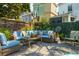 Comfortable outdoor space with plush seating, a brick wall, and lush greenery at 171 Queen St, Charleston, SC 29401
