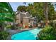Picturesque backyard featuring a pool, garden, patio and views of a two-story, tan-colored home at 171 Queen St, Charleston, SC 29401