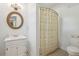 Bright bathroom with a vanity cabinet, round mirror, and a shower with a stylish patterned curtain at 171 Queen St, Charleston, SC 29401