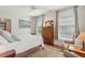 Bright bedroom featuring a wooden bed frame, antique cabinet, and comfortable seating area by the windows at 171 Queen St, Charleston, SC 29401