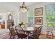 Bright dining room with ample windows, chandelier, and wooden table with seating for eight at 171 Queen St, Charleston, SC 29401