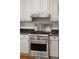 Close-up of the stainless steel stove and oven in the kitchen, showcasing granite counters at 171 Queen St, Charleston, SC 29401