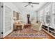 Bright living room with patterned rug, ceiling fan, and ample natural light from large windows at 171 Queen St, Charleston, SC 29401