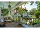 Charming porch with a swing, white railing, vintage hanging lamp, and lush landscaping at 171 Queen St, Charleston, SC 29401