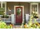 Close-up of a porch with a red door and charming details like flower boxes and vintage decor at 171 Queen St, Charleston, SC 29401