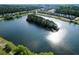Aerial view of a community with a lake, surrounded by lush green trees and well-maintained homes at 1894 Brittlebush Ln, Johns Island, SC 29455