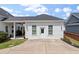 Home's rear exterior showcasing a charming home design with a covered patio, landscaped yard, and a spacious driveway at 1894 Brittlebush Ln, Johns Island, SC 29455