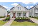 Charming home featuring a covered front porch with stylish landscaping and a striking red front door at 1894 Brittlebush Ln, Johns Island, SC 29455