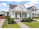 Beautiful home with a covered porch, manicured lawn, and inviting outdoor seating area at 1894 Brittlebush Ln, Johns Island, SC 29455