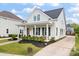 Inviting curb appeal with a classic white exterior, manicured lawn, and a covered front porch at 1894 Brittlebush Ln, Johns Island, SC 29455