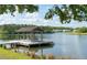 Scenic view of a lake with a wooden dock and seating, framed by lush greenery and serene water at 1894 Brittlebush Ln, Johns Island, SC 29455