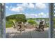 Outdoor patio with a brick fire pit surrounded by Adirondack chairs overlooking a tranquil lake at 1894 Brittlebush Ln, Johns Island, SC 29455