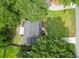 An aerial view shows a home's dark roof, manicured lawn, and proximity to mature trees and adjacent streets at 2020 Piper Dr, Charleston, SC 29407