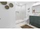 Bathroom showcasing tiled standing shower, white toilet and green vanity with a dark woven rug at 2020 Piper Dr, Charleston, SC 29407