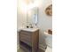 Bathroom featuring wood style vanity, square mirror, decorative basket, and toilet with black and grey rug at 2020 Piper Dr, Charleston, SC 29407