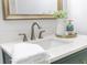 Close up of bathroom vanity with fresh flowers, gold hardware, and stylish faucet at 2020 Piper Dr, Charleston, SC 29407