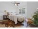 Bedroom with hardwood floors, cowhide rug, ceiling fan, two side tables, bed and brown leather chair at 2020 Piper Dr, Charleston, SC 29407