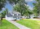 Inviting two-story home with a well-manicured lawn, long driveway, and classic architectural details at 2020 Piper Dr, Charleston, SC 29407