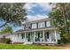 Inviting two-story home with a charming front porch, classic shutters, and lush green lawn at 2020 Piper Dr, Charleston, SC 29407